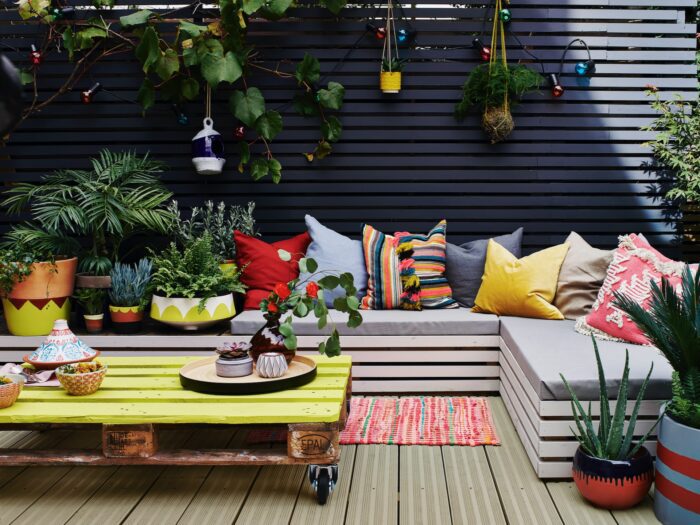 Charcoal painted garden fence with bench seating and hanging pots
