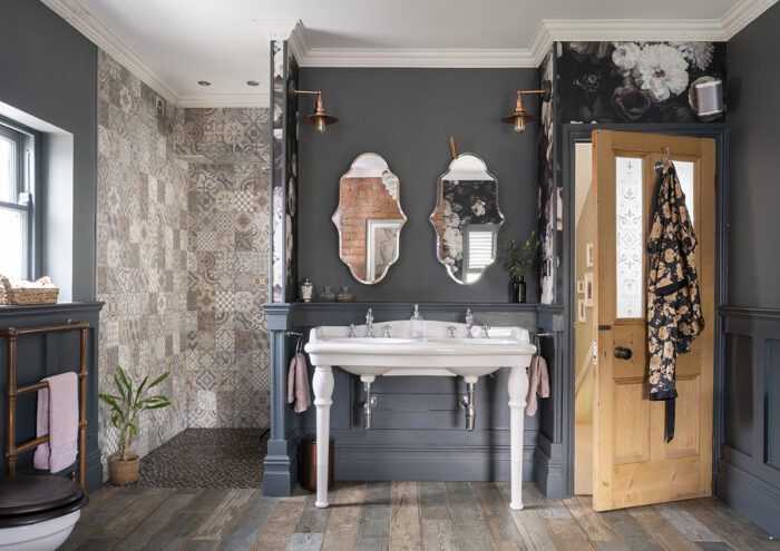 SIDE BY SIDE Building out a wall for a walk-in shower also meant creating an alcove which was the ideal spot for the vanity unit, with double sinks to beat the morning rush and matching wall lights and mirrors.