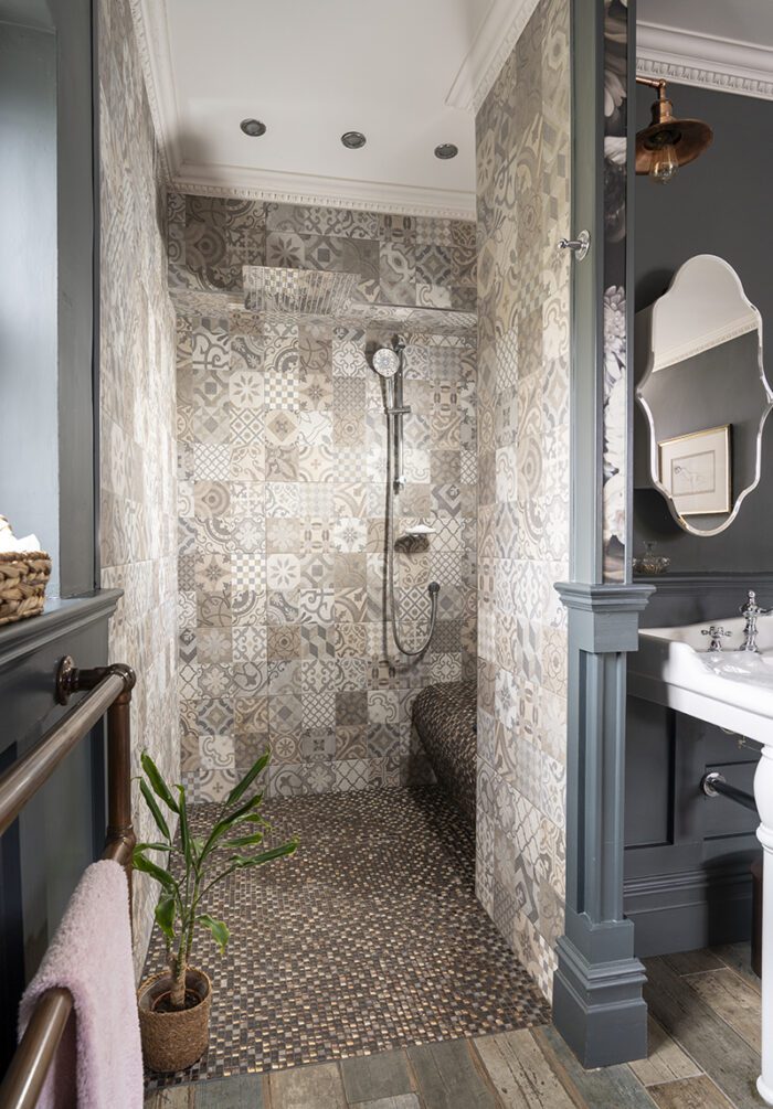 SIDE BY SIDE
Building out a wall for a walk-in shower also meant creating an alcove which was the ideal spot for the vanity unit, with double sinks to beat the morning rush and matching wall lights and mirrors.